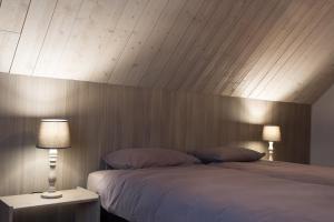 a bedroom with a large bed with a wooden headboard at VILLA WESTHOEK in Poelkapelle