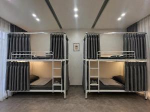 two bunk beds in a room with curtains at Behomestay in Hai Phong