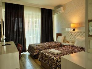 a hotel room with two beds and a window at CLUB MONTE CARLO HoTEL in Alanya