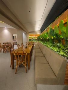 a restaurant with tables and chairs and plants on the wall at Hotel De Green Lampung in Lampung