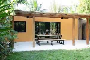 a patio with a table under a pergola at Red Palm Villa in San Vicente