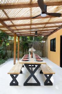 a wooden picnic table under a wooden pergola at Red Palm Villa in San Vicente