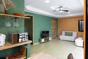 a living room with a couch and a microwave at Red Palm Villa in San Vicente