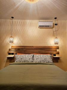 a bedroom with a bed with two lights on the wall at Red Palm Villa in San Vicente