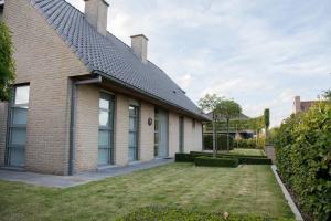 a brick house with a yard in front of it at VILLA WESTHOEK in Poelkapelle