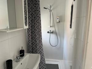 a white bathroom with a shower and a sink at Tomi Apartman in Velence +8 photos