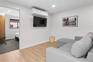 a living room with a couch and a flat screen tv at Barooga Hotel in Barooga