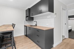 a kitchen with black cabinets and a counter top at Barooga Hotel in Barooga +7 photos