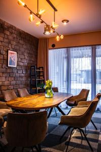 a dining room with a wooden table and chairs at Desimo Home in Piła