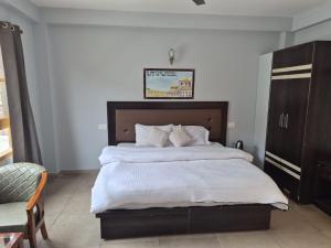a bedroom with a large bed with white sheets at Hotel Sidharth Tabo in Tabo