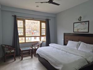 a bedroom with a large bed and a window at Hotel Sidharth Tabo in Tabo