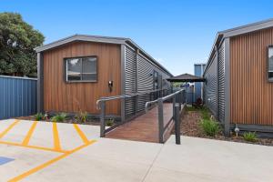 a modular home with a wooden deck next to a building at Barooga Hotel in Barooga