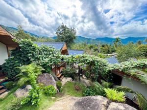 a house with a garden with rocks and trees at Yod Khao Muay Thai Camp in Ban Nok