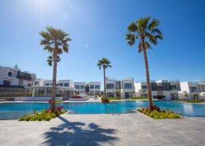 a resort with palm trees and a swimming pool at Aqualina E4-1 by HolidayKeys in Kyrenia