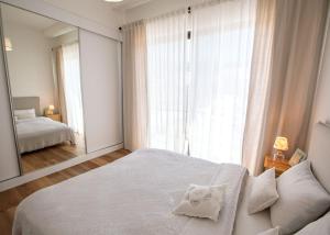 a bedroom with a white bed and a large mirror at Aqualina E4-1 by HolidayKeys in Kyrenia