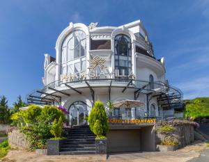 a large white building with stairs in front of it at Dalat Hotel & Villa by Pham Gia in Xuan An