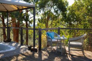 a deck with a table and chairs and a bath tub at Avalon in Hepburn Springs +2 photos
