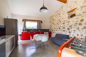 a kitchen and living room with a table and a couch at Gîte la Pigne in Aurel