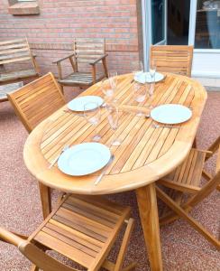 a wooden table with plates and wine glasses on it at Trésor de Beaurains in Beaurains