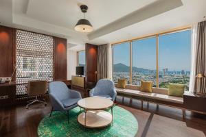 a living room with a couch and chairs and a table at Hilton Da Nang in Danang