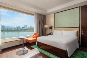 a hotel room with a bed and a large window at Hilton Da Nang in Danang