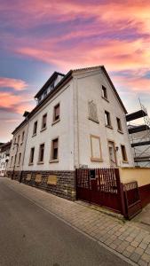 a white building on the side of a street at Design Apartment Arndt in Neustadt an der Weinstrasse in Neustadt an der Weinstraße