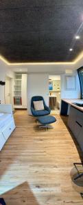 a living room with a blue chair and a table at Design Apartment Arndt in Neustadt an der Weinstrasse in Neustadt an der Weinstraße