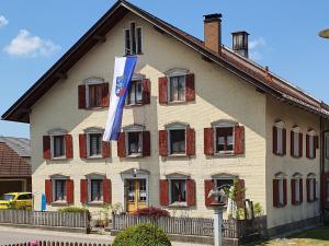 a building with a flag in front of it at Ferienwohnung Dorfleben in Weiler-Simmerberg