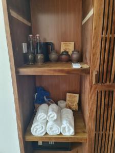 a wooden shelf with towels and other items on it at Mai Châu Home in Mai Châu