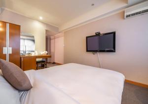 a hotel room with a bed and a flat screen tv at Ansan Seowon Tourist Hotel in Ansan