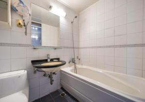 a white bathroom with a sink and a bath tub at Ansan Seowon Tourist Hotel in Ansan