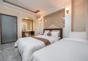 a hotel room with two beds and a mirror at Ansan Seowon Tourist Hotel in Ansan +9 photos