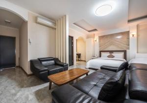 a hotel room with a bed and a couch and a table at Ansan Seowon Tourist Hotel in Ansan