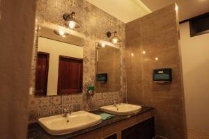 a bathroom with two sinks and a large mirror at Nam Phou Hostel in Thakhek +30 photos