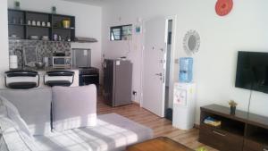 a living room with a couch and a tv and a kitchen at Modern apartment for work and rest in Kiambu