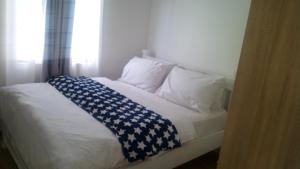 a bed with a blue and white blanket on it at Modern apartment for work and rest in Kiambu