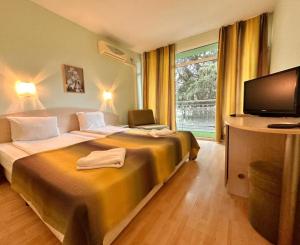 a hotel room with two beds and a flat screen tv at Dalis Sunny Beach in Sunny Beach +1 photo