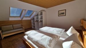 a small bedroom with two beds and a couch at Residence Granvara in Ortisei