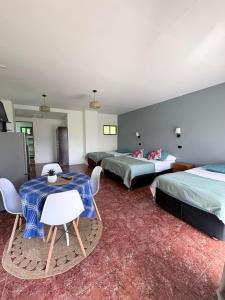 a room with three beds and a table and chairs at Cabañas Honu Nui Inn in Hanga Roa