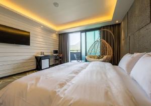 a large white bed in a room with a window at Anyang Boutique Hotel AMA in Anyang