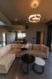 a woman sitting on a couch in a living room at Secret Paradise Edge in Weligama