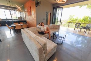 a woman sitting on a couch in a living room at Secret Paradise Edge in Weligama