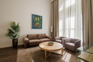 a living room with a couch and chairs and a table at Apartments Kozmo Residences Budapest in Budapest