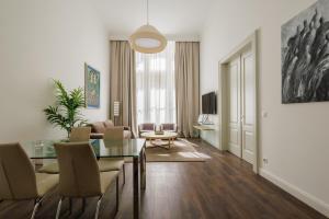 a living room with a glass table and chairs at Apartments Kozmo Residences Budapest in Budapest