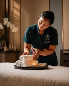 a woman standing on top of a bed with a plate at Copthorne Hotel Sharjah in Sharjah