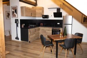 a kitchen with a table and chairs and a refrigerator at Loft Sous Pref in Montbéliard