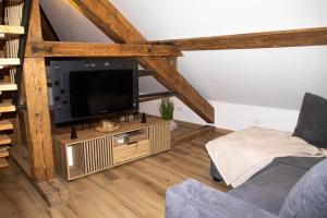 a living room with a tv on a wooden stand at Loft Sous Pref in Montbéliard