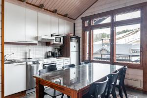 a kitchen with a table and chairs and a large window at Himos Mökki superior - Chalet Cottage superior ski-in-ski-out in Jämsä