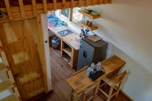 an overhead view of a kitchen with a table and a refrigerator at Colibri - Cabañas Puerto del Zopilote in Pinal de Amoles
