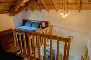 an attic room with a bed and a staircase at Colibri - Cabañas Puerto del Zopilote in Pinal de Amoles